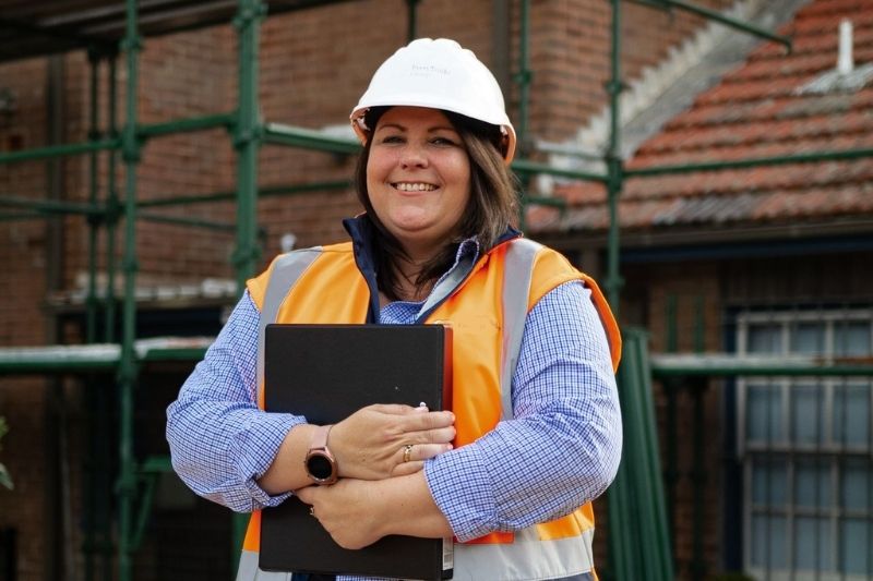 Woman in hard hat and safety vest smiling